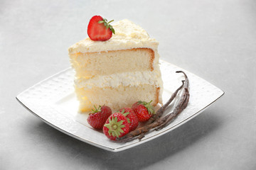 Piece of delicious vanilla cake on table