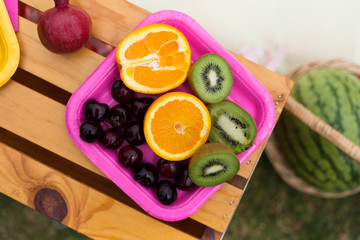 Fruits on the plate, orange, kiwi, pomegranate, grape, cherry. Photo decoration. Romantic