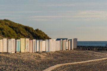 Colorful sheds at the beach in front of dunes sunset