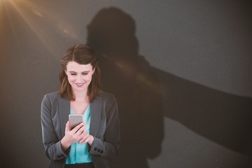 Composite image of businesswoman using mobile phone