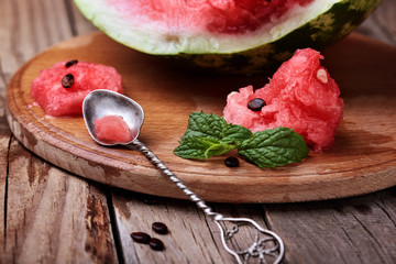 Watermelon.loseup watermelon and leaf of mint on vintage spoon onwooden rustic table with.Selective focus.