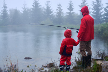 Father and son fishing on the lake - obrazy, fototapety, plakaty