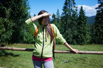 Pensive female looking at distance while hiking in mountains