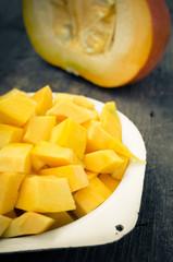 Autumn raw sliced pumpkin on rustic wooden background
