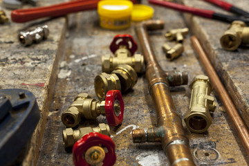 Gate valves and copper pipe on a wooden workbench