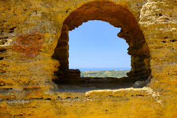Obraz premium Looking through an ancient window to the distant sea