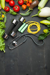 Fresh vegetables, diet and sport on a black wooden background - 170374454