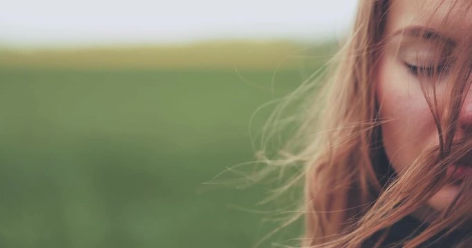 Close Up Portrait of Woman Standing on the Wind. SLOW MOTION 4K DCi. Breeze is playing with girls hair. Stormy weather, autumn, winter, spring. 