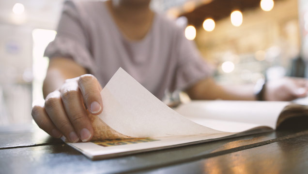 Young woman reading a book in cafe.