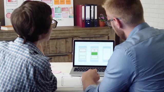 Mobile app developer explaining his design concept to the coworker