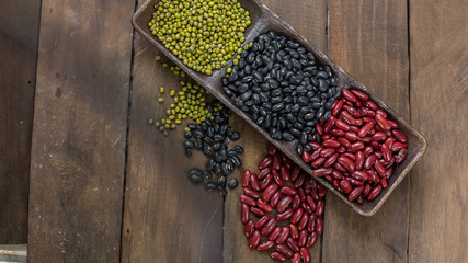 Green beans, black beans, red beans on the wood background.