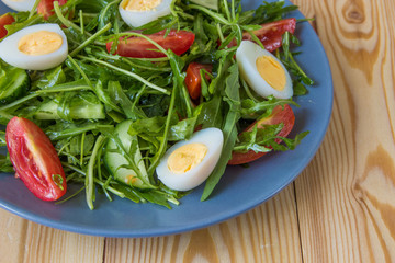 Fresh green salad with arugula, tomatoes, eggs and cucumber