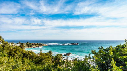De turquoise golven van de Atlantische Oceaan beuken op de kusten bij Camps Bay, een strandgemeenschap in de buurt van Kaapstad, Zuid-Afrika