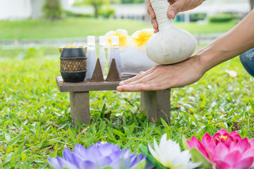Female hand with Spa massage compress balls, herbal ball on the wooden with treaments spa, relax...