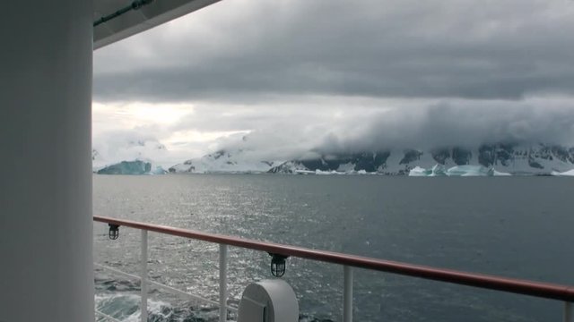 Ice movement and snow iceberg and glacier view from ship in ocean of Antarctica. Amazing unique beautiful wilderness nature and landscape of white mountains. Extreme tourism cold desert north pole.
