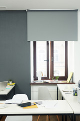 Workplace of office manager with tablet and papers and chair by desk