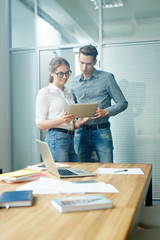 Young professionals with digital tablet browsing in the net in office