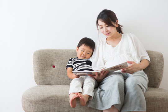 男の子に絵本を読む妊婦さん