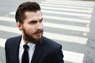 Attractive and elegant man with beard and moustache wearing suit