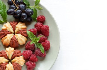 Biscuit with fresh berries on white plate. Selective focus. Copy space