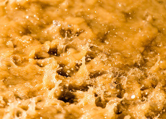 Rain drops fall into a dirty puddle