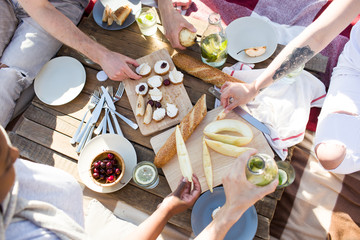 Human hands over served table with drinks, snacks and fruit