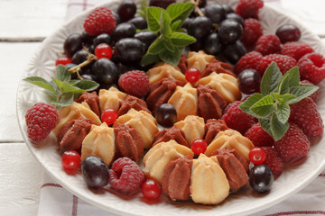 Biscuit with fresh berries on white plate. Selective focus.