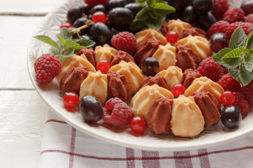 Biscuit with fresh berries on white plate. Selective focus.