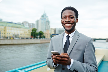 Successful business leader with gadget traveling by steamship