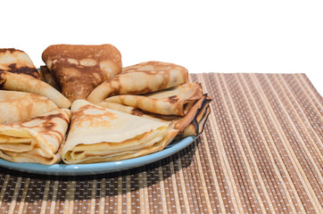 Russian traditional dishes - pancakes on a plate on a bamboo napkin