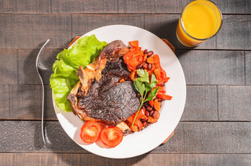 Fried beef steak with vegetables and beans on a plate