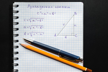Page with formulas and the Pythagorean theorem with pen and pencil