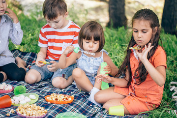 Children on grass smiling and playing in spinner