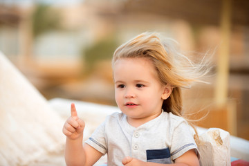 Boy child with cute smiling face pointing with pointer finger