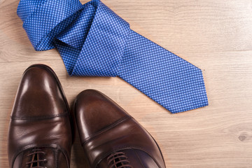 Men's accessories men's shoes, tie on a wooden background. Classic men's accessories. Top view