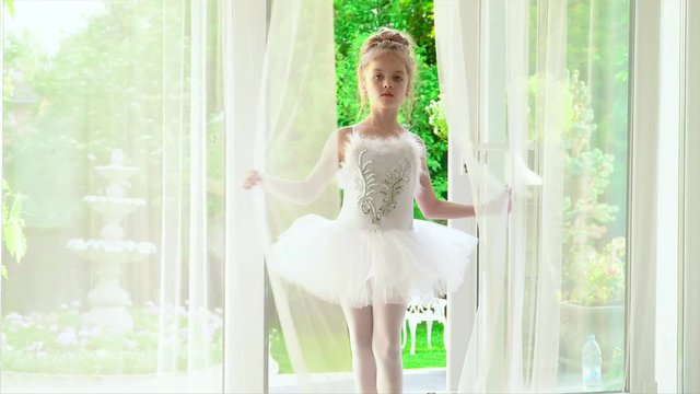 Beautiful maleny girls in ballet white packs dance on music at ballet school