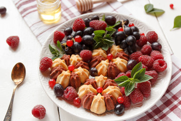 Biscuit with fresh berries on white plate. Selective focus.