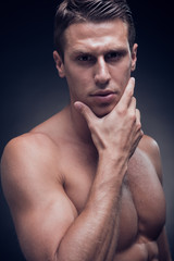headshot, face head headshot close up, one young adult man, fitness model, muscular, head and shoulders shot, Caucasian, hand on chin, black background,