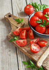 red tomatoes on a wooden board with parsley. country style