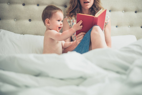 Mother in bed reading to her baby