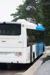 Electric bus at a stop is charged by wireless charging