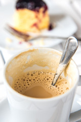 cup of latte, cappuccino or espresso coffee with cake on a background.