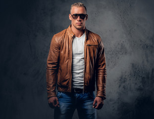 A man in sunglasses and brown leather jacket.
