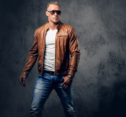 A man in sunglasses and brown leather jacket.