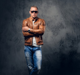 A man in sunglasses and brown leather jacket.