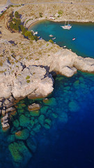Aerial drone photo of famous beach of Lindos with turquoise waters and iconic ancient Acropolis - village of Lindos, Rodos island, Aegean, Dodecanese, Greece