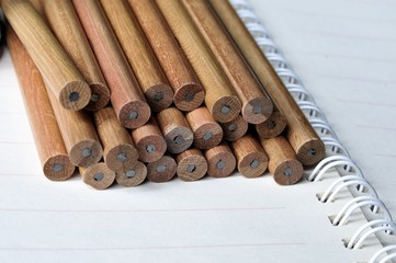 group of pencils on open notebook and show a spiral binder of notebook