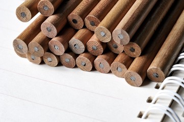 group of pencils on open notebook and show a spiral binder of notebook