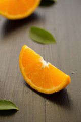 Orange sliced and leaves on black wooden background