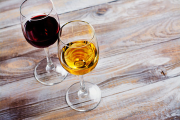 Red and white wine in glasses with grapes on white background. Assortment of autumn harvest beverages. Copy space